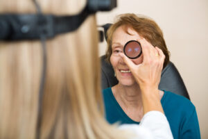 Mulher idosa sendo examinada por uma oftalmologista para ver se tem retinopatia diabética